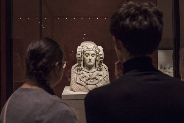 Visitors observing the Lady of Elche bust