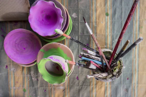 Clay pieces and glass full of used brushes — Stock Photo, Image