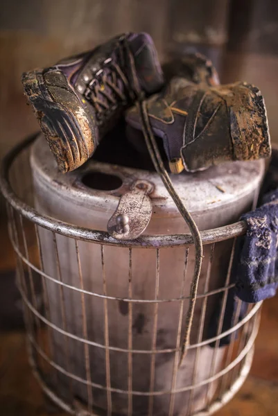 Wet used boots and socks drying over firewood stove — Stockfoto