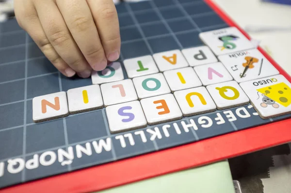 Child practices with word formation board game