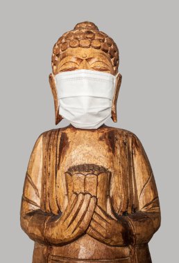 Yüz maskesi takan Buda heykeli. Gri üzerine izole edilmiş. Covid-19 konsepti