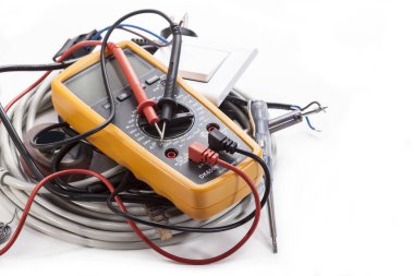 Beyaz arka planda çoklu metre, test cihazı, lehim ve elektrik kablosu.