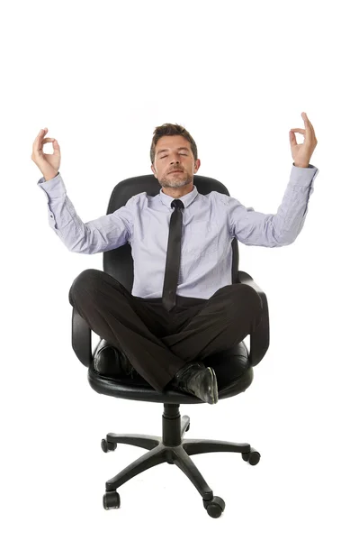 Молодой привлекательный счастливый бизнесмен расслабляется с руками в положении йоги сидя на офисном стуле — стоковое фото