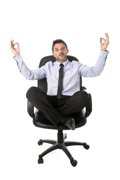 Young attractive happy businessman relaxing with hands in yoga position sitting on office chair — Zdjęcie stockowe