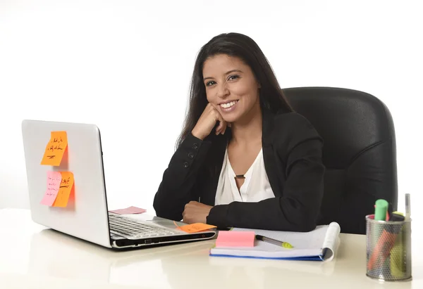 Привлекательная латиноамериканская деловая женщина, сидящая за столом офиса и работающая на ноутбуке, улыбаясь счастливой — стоковое фото
