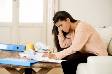 young attractive latin woman at home living room couch calculating monthly expenses worried in stress