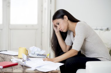young attractive latin woman at home living room couch calculating monthly expenses worried in stress