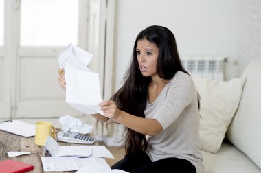 young attractive latin woman at home living room couch calculating monthly expenses worried in stress