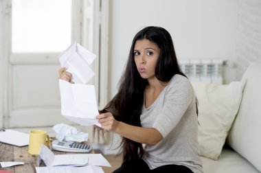 young attractive latin woman at home living room couch calculating monthly expenses worried in stress