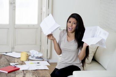 young attractive latin woman at home living room couch calculating monthly expenses worried in stress