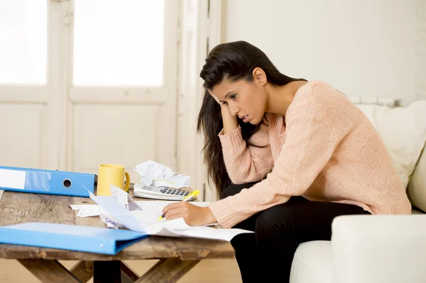 Young attractive latin woman at home living room couch calculating monthly expenses worried in stress — Stockfoto