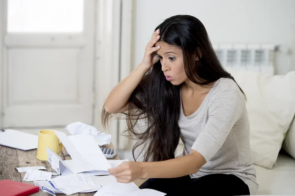 Young attractive latin woman at home living room couch calculating monthly expenses worried in stress — Stockfoto