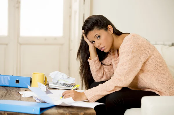 Young attractive latin woman at home living room couch calculating monthly expenses worried in stress — Stock fotografie