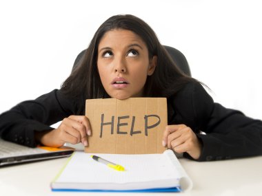 young busy desperate Latin businesswoman holding help sign sitting at office desk in stress worried