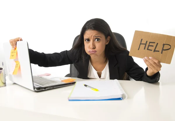 Young busy desperate Latin businesswoman holding help sign sitting at office desk in stress worried — Stockfoto