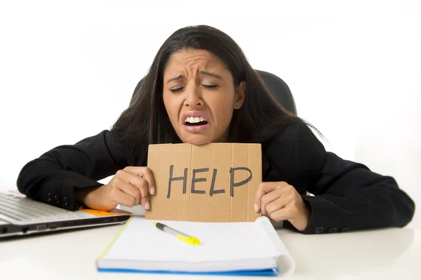 Young busy desperate Latin businesswoman holding help sign sitting at office desk in stress worried — Stock fotografie