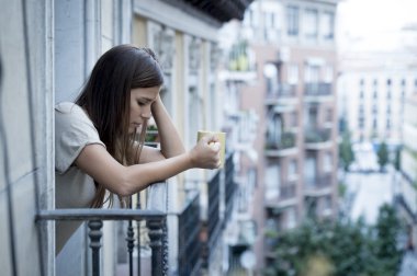 young sad beautiful woman suffering depression looking worried and wasted on home balcony