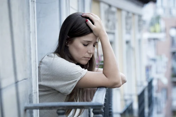 Young sad beautiful woman suffering depression looking worried and wasted on home balcony — Stock fotografie