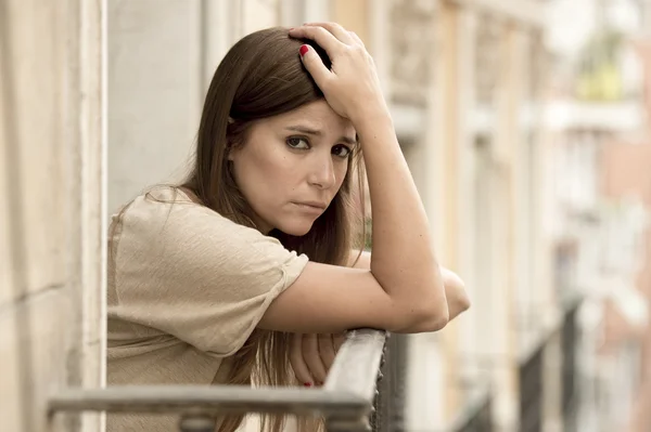 Jeune triste belle femme souffrant de dépression l'air inquiet et gaspillé sur le balcon de la maison — Photo