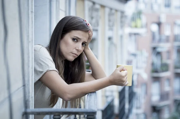 Young sad beautiful woman suffering depression looking worried and wasted on home balcony — Stok fotoğraf