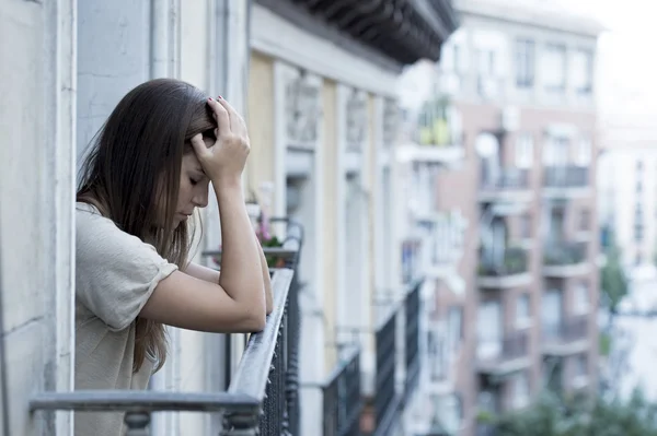 Joven triste hermosa mujer sufriendo depresión buscando preocupado y desperdiciado en casa balcón —  Fotos de Stock