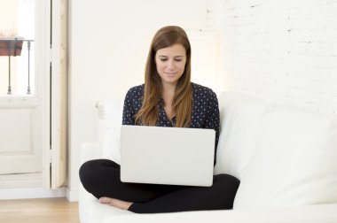 mutlu güzel 30'lu ağ ev modern oturma odası, gülümseyen dizüstü bilgisayar kullanan kadın rahat