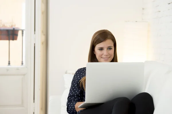 Wanita cantik yang bahagia 30-an menggunakan laptop tersenyum jaringan di rumah ruang tamu modern santai — Stok Foto