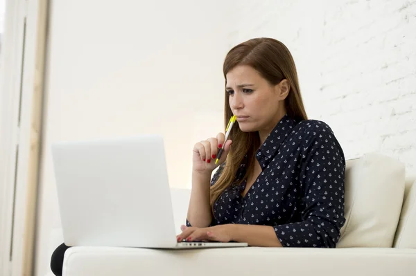 Женщина с помощью ноутбука компьютерных сетей или интернет-покупки на домашнем диване — стоковое фото