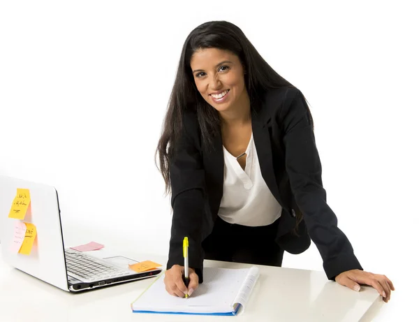 Attractive hispanic businesswoman or secretary taking notes standing leaning on office computer desk — Φωτογραφία Αρχείου