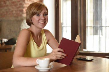 güzel kadın kahve ya da çay mutlu gülümseyen içme kahve dükkanında kitap okuma keyfi 