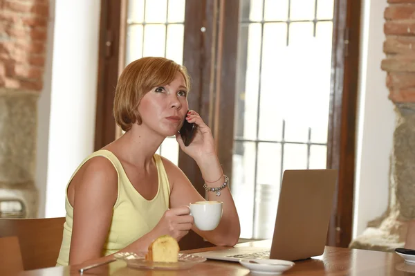 Vrouw die drukke werkt bij koffieshop met laptopcomputer praten op mobiele telefoon — Stockfoto