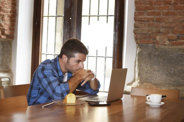 Uomo d'affari o studente che lavora con il computer portatile alla caffetteria facendo colazione — Foto Stock
