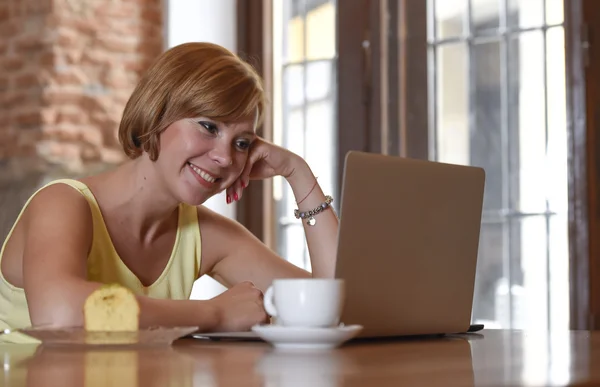 Bela mulher bem sucedida trabalhando no café com computador portátil apreciando xícara de café — Fotografia de Stock