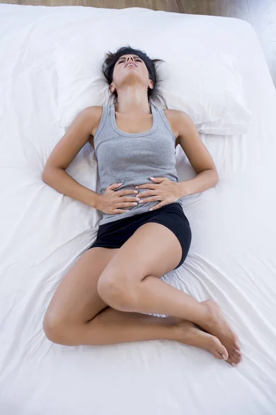 Bela mulher hispânica em expressão dolorosa segurando barriga sofrendo dor menstrual período — Fotografia de Stock
