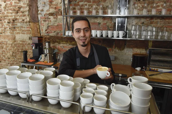 young italian barista or coffee maker at restaurant shop preparing milk cream at cafe machine