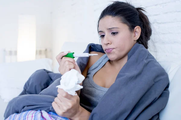 Junge attraktive hispanische Frau liegt krank zu Hause Couch in Erkältung und Grippe in meckerndem Krankheitssymptom — Stockfoto