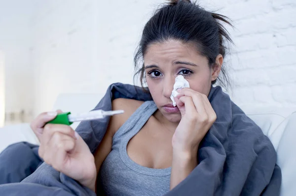 Joven mujer hispana atractiva acostada enferma en el sofá de casa en el resfriado y la gripe en la enfermedad de gripe síntoma —  Fotos de Stock