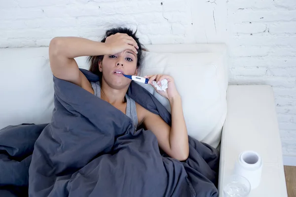 Ελκυστική Ισπανόφωνος γυναίκα ξαπλωμένη στο σπίτι άρρωστος καναπέ στο κρύο και τη γρίπη σε gripe σύμπτωμα της νόσου — Φωτογραφία Αρχείου