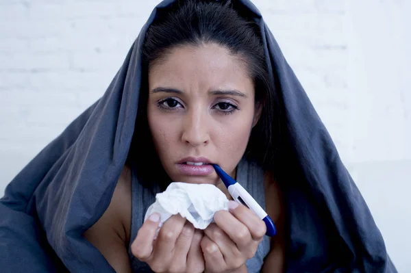 Jonge aantrekkelijke Spaanse vrouw liggend ziek thuis couch in koude en griep in gripe ziekte-symptoom — Stockfoto