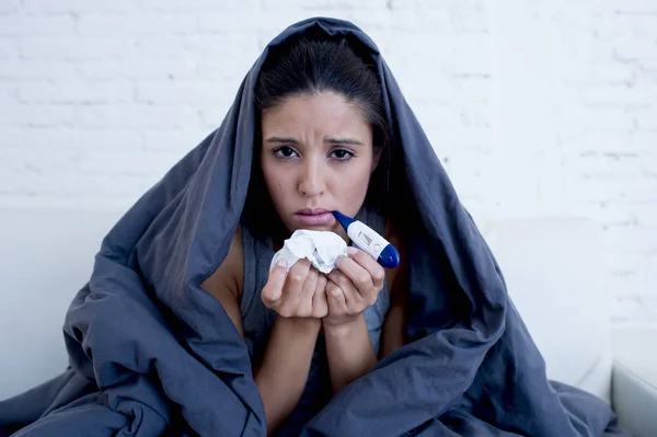 Joven mujer hispana atractiva acostada enferma en el sofá de casa en el resfriado y la gripe en la enfermedad de gripe síntoma —  Fotos de Stock