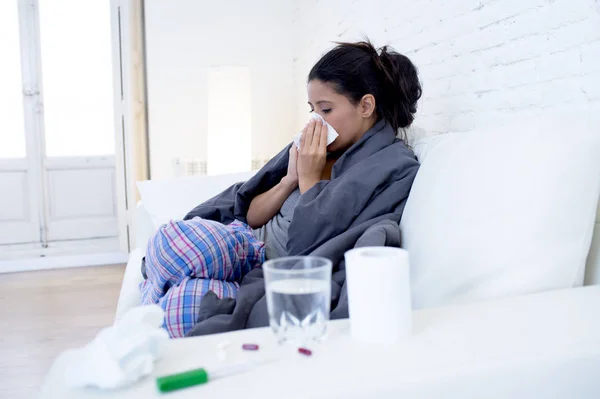 Junge attraktive hispanische Frau liegt krank zu Hause Couch in Erkältung und Grippe in meckerndem Krankheitssymptom — Stockfoto