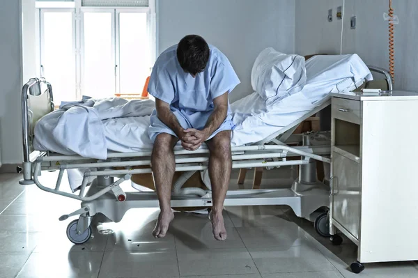 Desesperado hombre sentado en la cama del hospital solo triste y devastado s —  Fotos de Stock