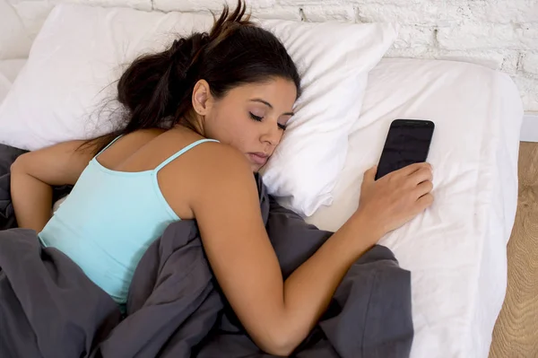 Vrouw slapen in bed thuis samen met mobiele telefoon in internet netwerk verslaving — Stockfoto