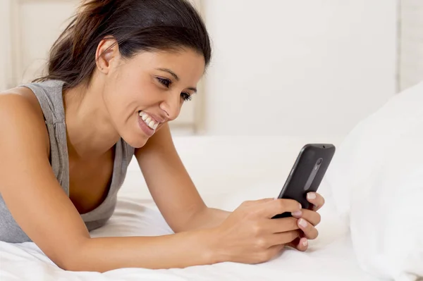 Ισπανόφωνος γυναίκα χαλαρή χρήση Διαδικτύου κινητού τηλεφώνου στέλνοντας μήνυμα στο σπίτι υπνοδωμάτιο χαμογελά ευτυχισμένη — Φωτογραφία Αρχείου
