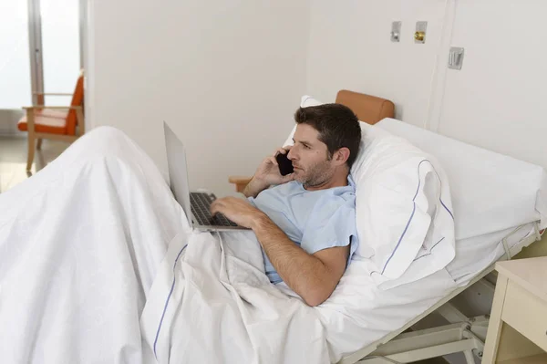 Empresário estagiário como paciente em hospital sofrendo de doença e trabalhando feliz e relaxado na cama clínica — Fotografia de Stock