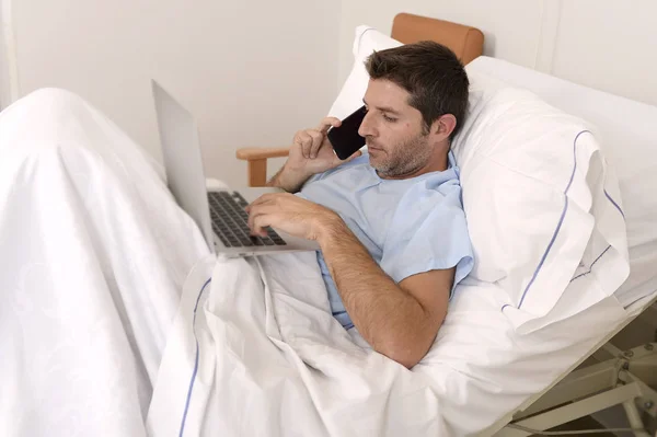 Businessman intern as patient in hospital suffering disease and working happy and relaxed at clinic bed — Stock Photo, Image