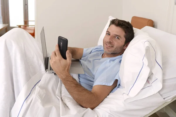 Empresário estagiário como paciente em hospital sofrendo de doença e trabalhando feliz e relaxado na cama clínica — Fotografia de Stock