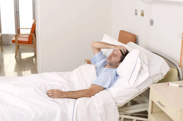 Hever a kórházi ágyon pihent, fáradt, szomorú és depressziós beteg fiatalember aggódik — Stock Fotó