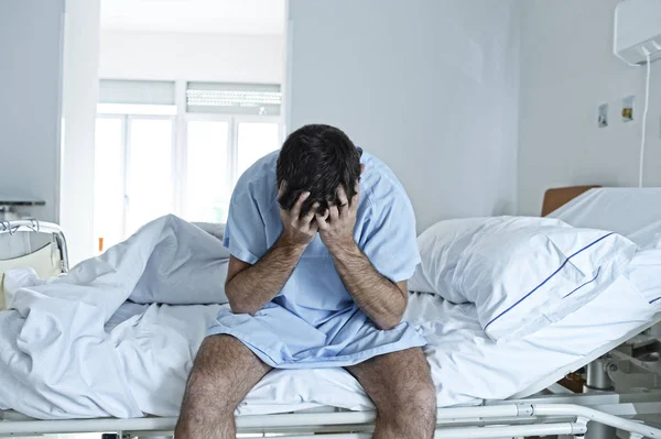 Kétségbeesett ember ül a kórházi ágy egyedül szomorú és elpusztult beteg Klinika — Stock Fotó