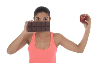 genç çekici İspanyol kadın fitness üst elma meyve ve çikolata onun elinde tutan